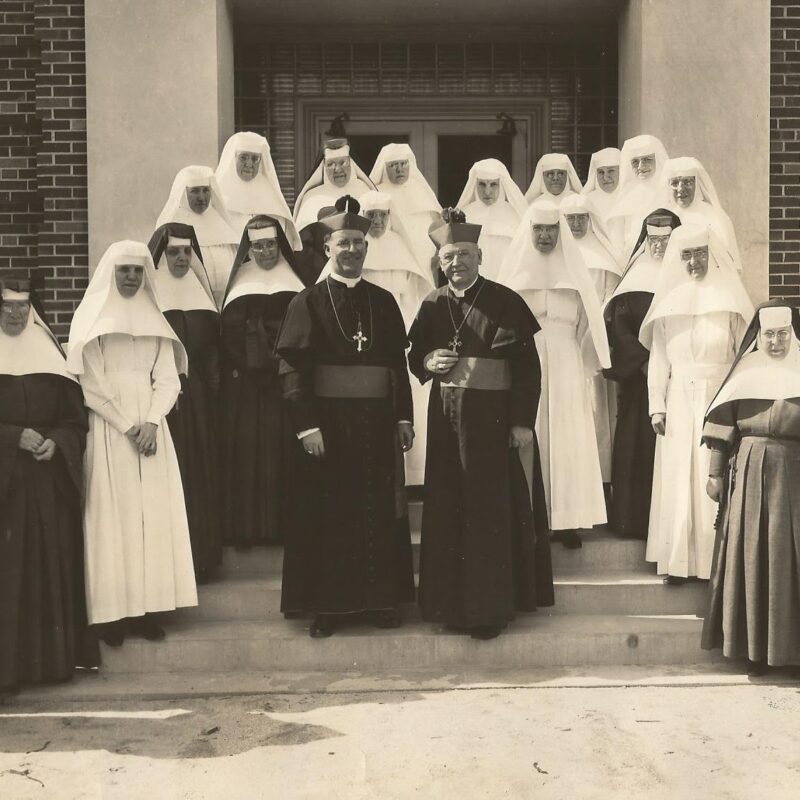 historic photo of the sisters with priests